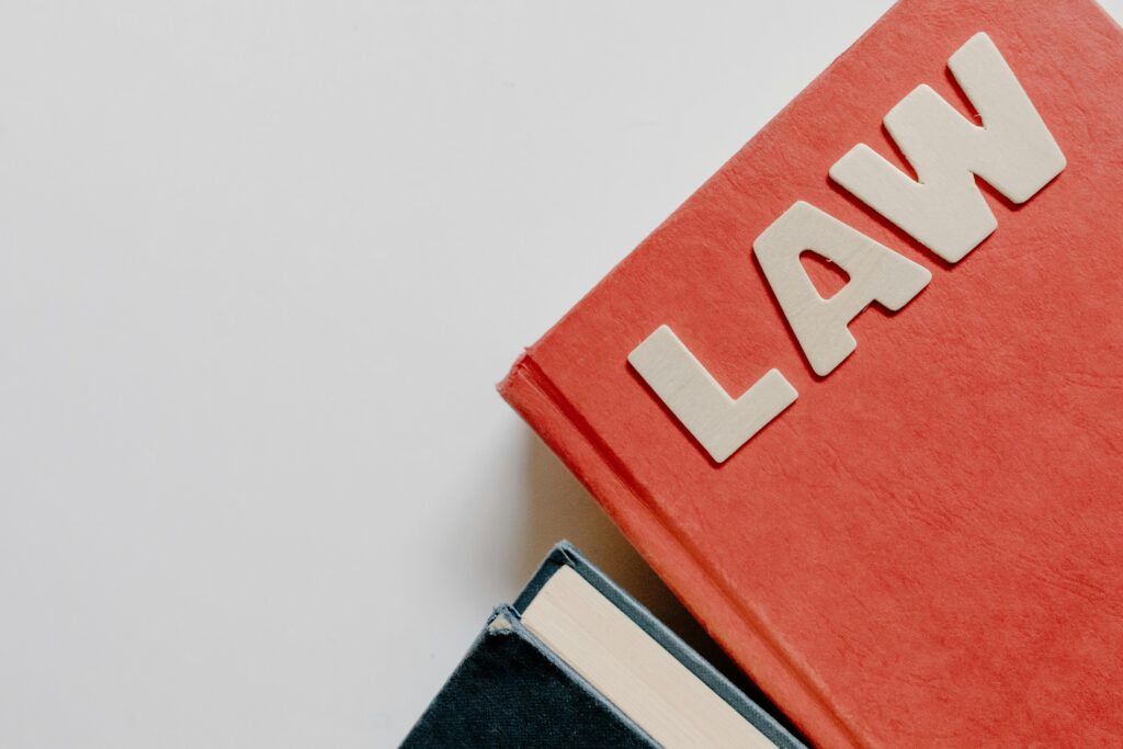 Red book with "Law" text in light brown on grey background, promoting Ink demo call-to-action.